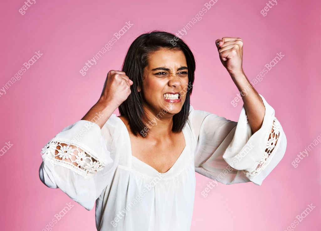 Beautiful young woman shakes her fists and grimaces in rage 이미지 ...