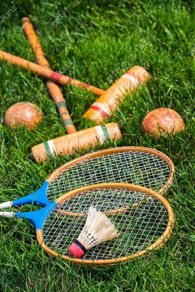 Vintage badminton rackets and croquet mallets lying in grass 이미지 ...