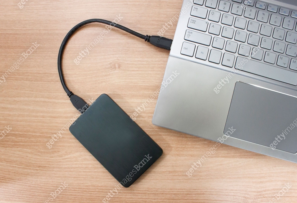Hard drive connected to the Laptop computer on wood texture 이미지 ...