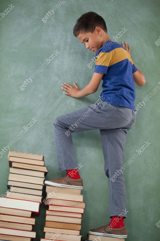 Schoolboy climbing steps of books stack 이미지 (820213016) - 게티이미지뱅크