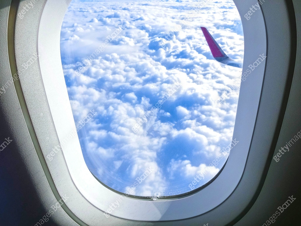 View of wing of an airplane flying above the clouds. Clouds and sky ...