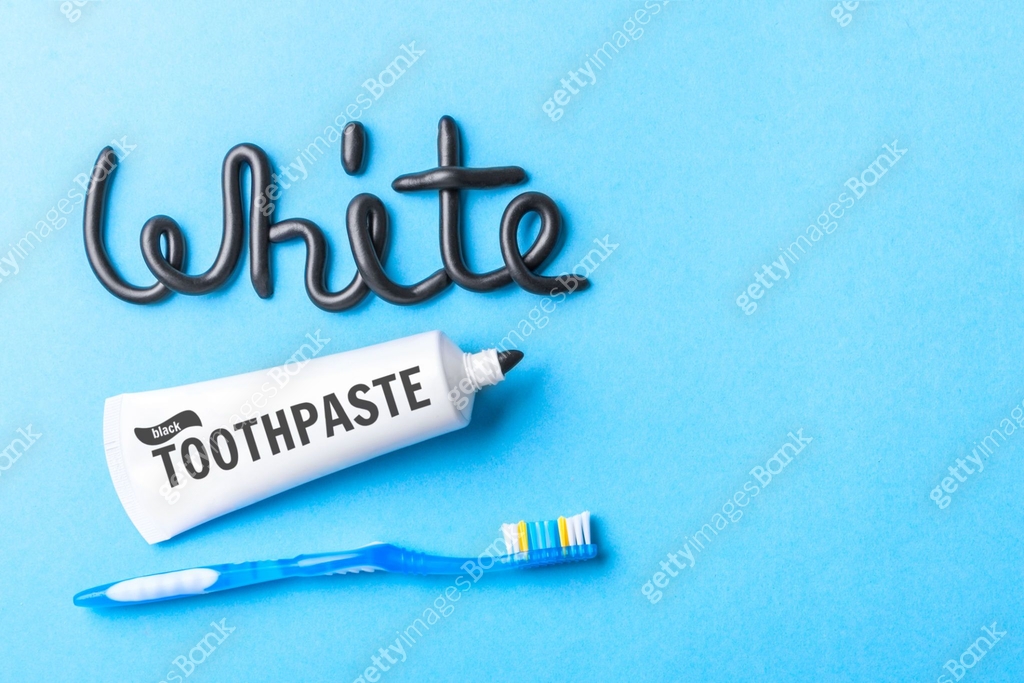 Black toothpaste from charcoal for white teeth. Word WHITE from black ...