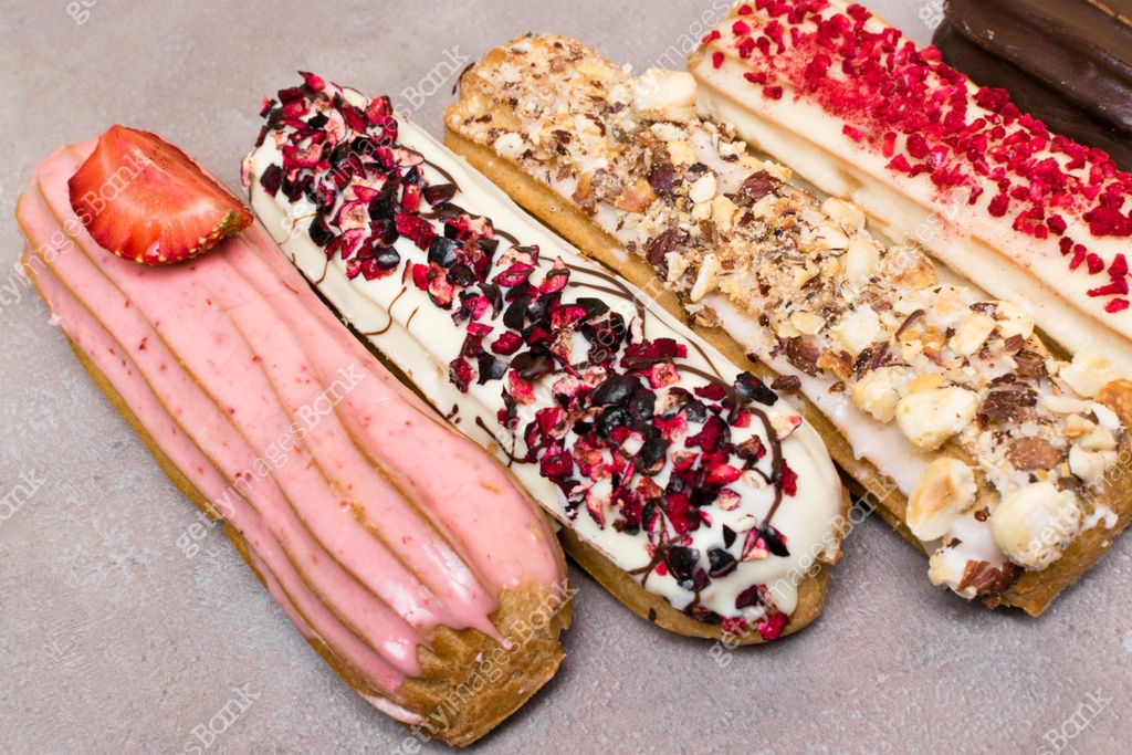 Sweet and colorful french eclairs with berrys, chocolate, nuts. Group ...