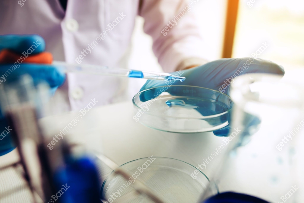 Lab technician examining doing compounds with using dropper taking a ...
