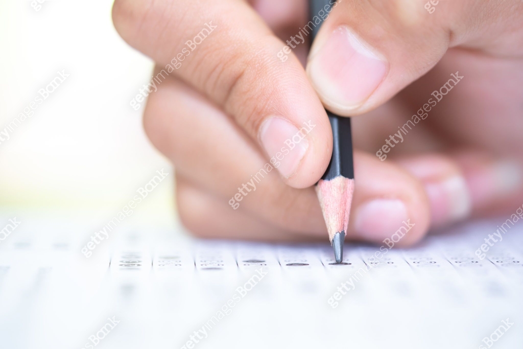Pencil on hand to writing answer of test examination on answer paper ...