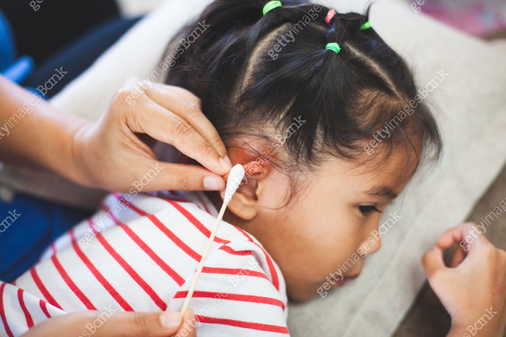 Parent helping her child perform first aid ear injury after she has ...