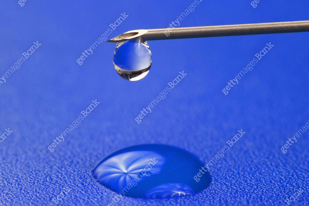 close-up of a drop of medicine on the tip of a medical injection needle ...