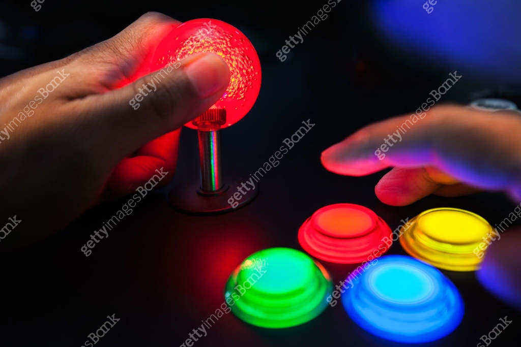 A red lighted arcade joystick and four button layout push buttons being ...