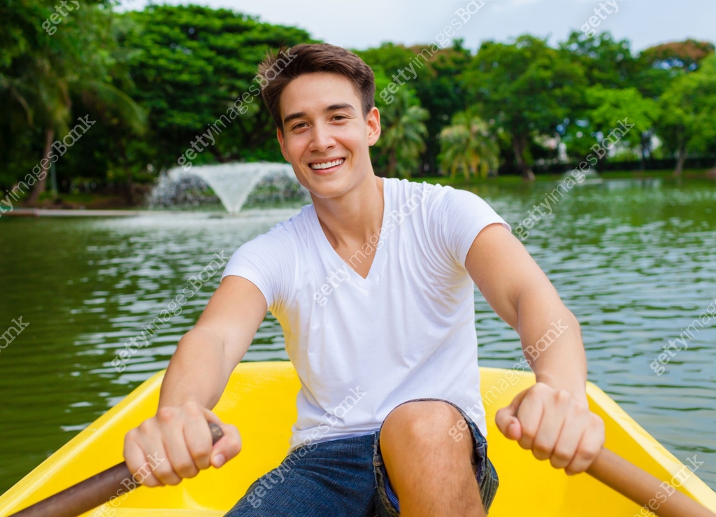 Smiling young man rowing a boat on the lake 이미지 (1164225984) - 게티이미지뱅크