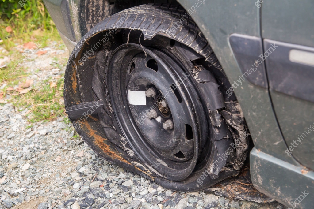Tyre Exploded Destroyed blown out tire with exploded, shredded and damaged tire on a ...