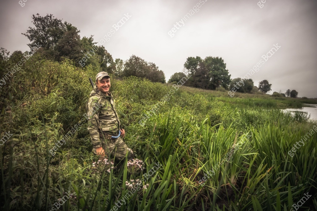Hunting hunter man hiding in reed swamp tall grass during hunting ...