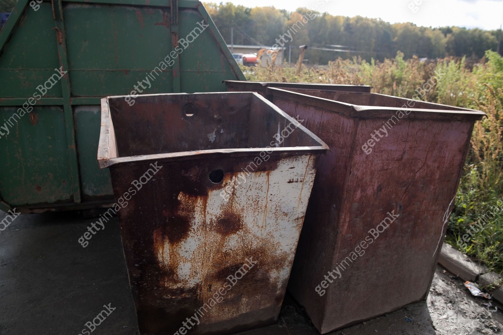 Dumpsters being full with garbage an old rusty trash can, green trash ...