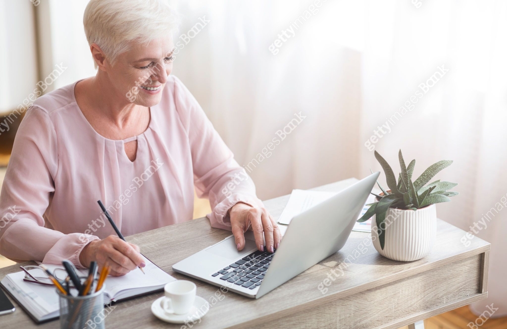 Lady Making Notes Top view of mature working lady making notes, using laptop 이미지 ...