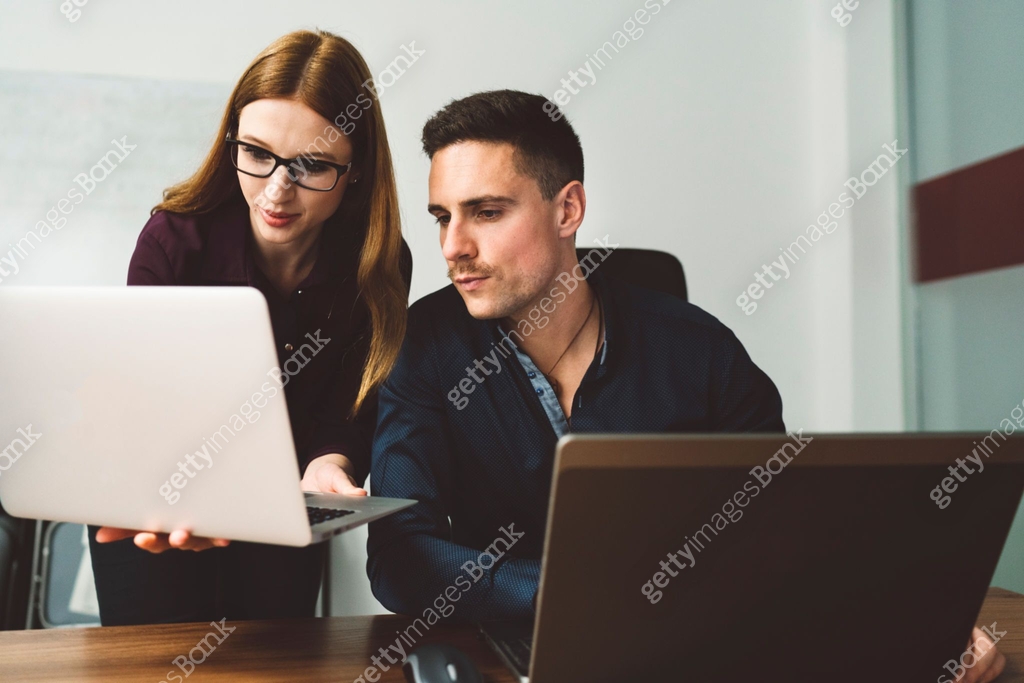 Two programmers, a man and a woman looking at one laptop screen 이미지 ...