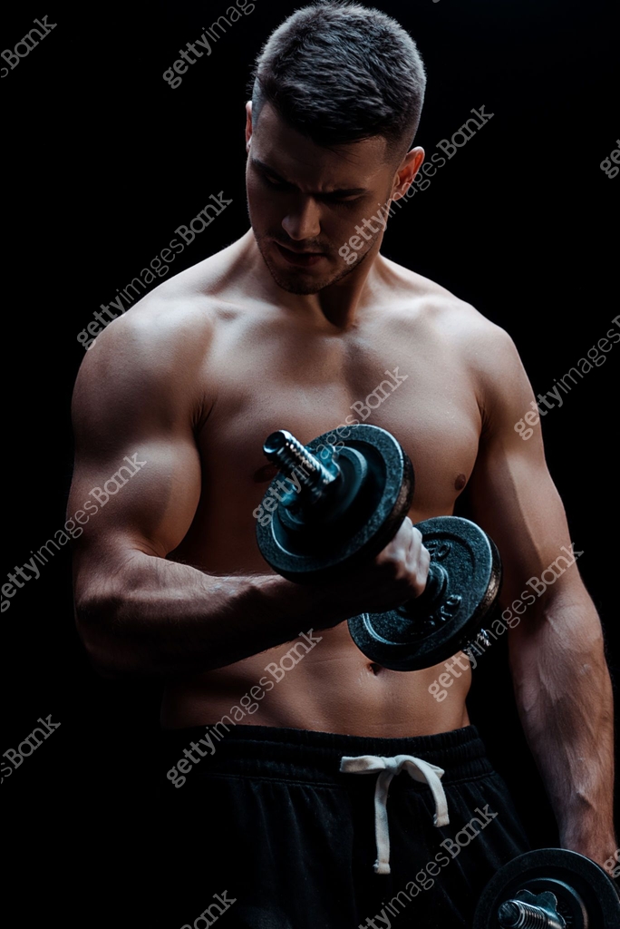 sexy muscular bodybuilder with bare torso excising with dumbbell ...