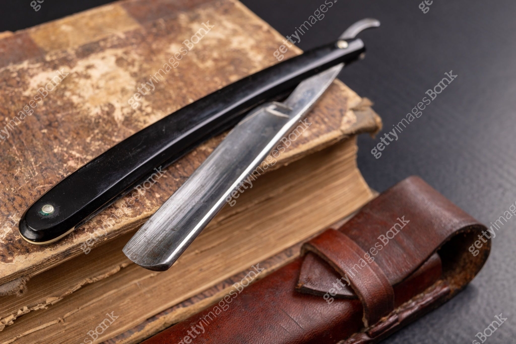Photography Razor Table Old sharp razor and book on the table. Accessories for hairdressers and ...