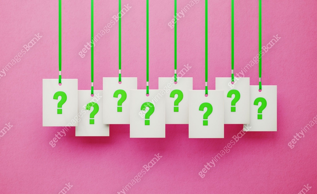 Question Marks on White Price Tags Hanging from Green Ribbons over Pink ...