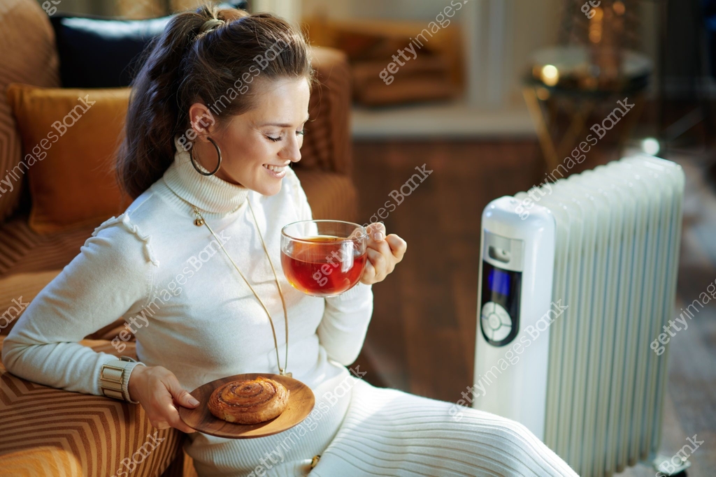 smiling trendy woman and radiator with tea cup and bun 이미지 (1205906373 ...