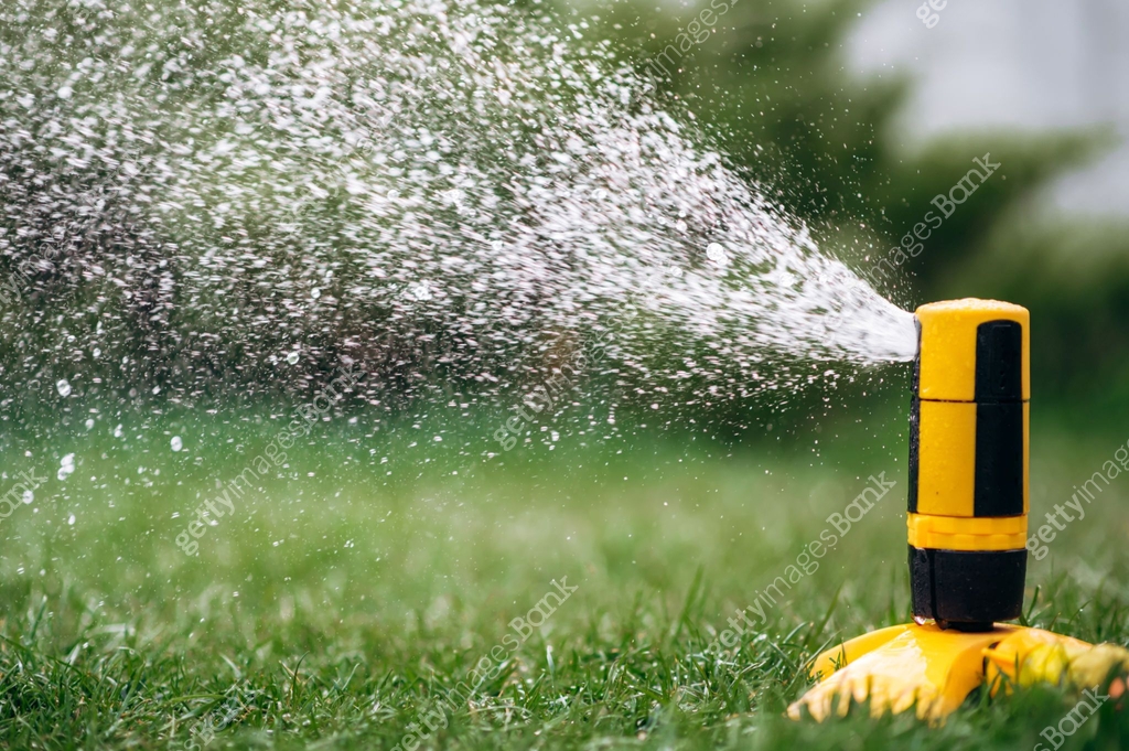 watering sprinkle irrigation system grass lawn green summer raindrops ...