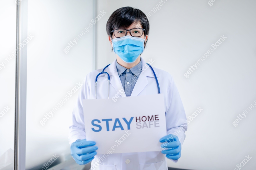 Doctor showing paper Stay home Stay safe 이미지 (1243609385) - 게티이미지뱅크