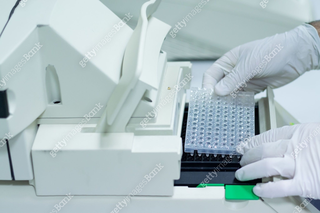 Researcher or scientific introducing a plate in quantitative PCR ...