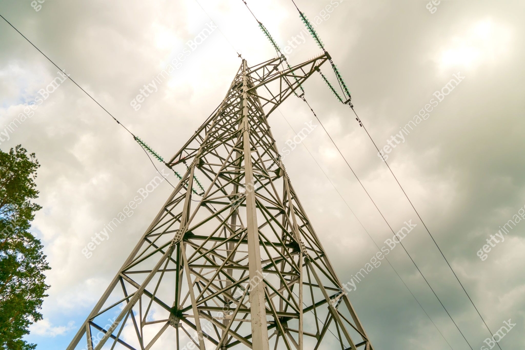 High-voltage power line against a cloudy sky with flashes of blue sky ...