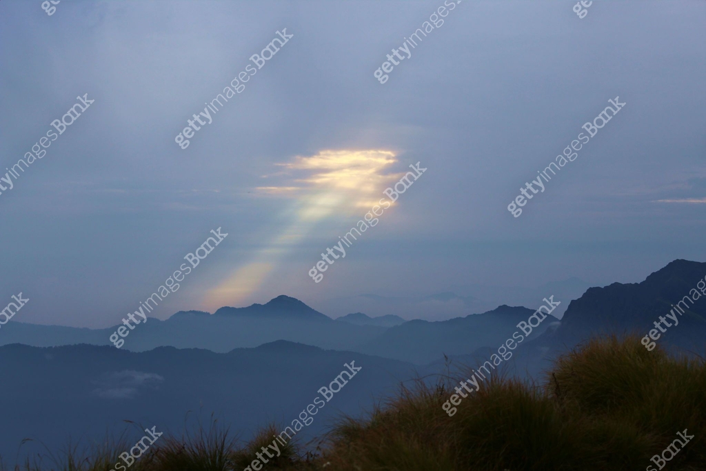 lower Himalayan mountain peaks with sun rays come out from the hole in ...