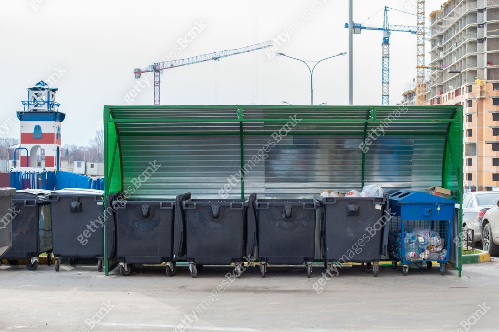 Lots of black plastic trash containers, residential area new building ...
