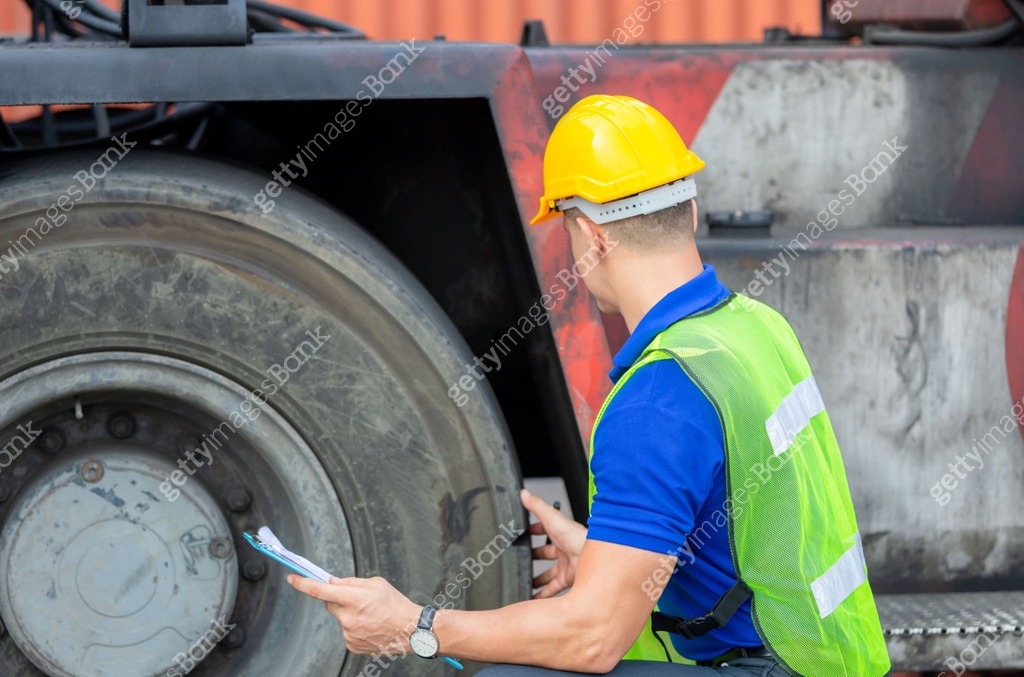 Mechanics checking wheel in cargo container. Professional technician ...