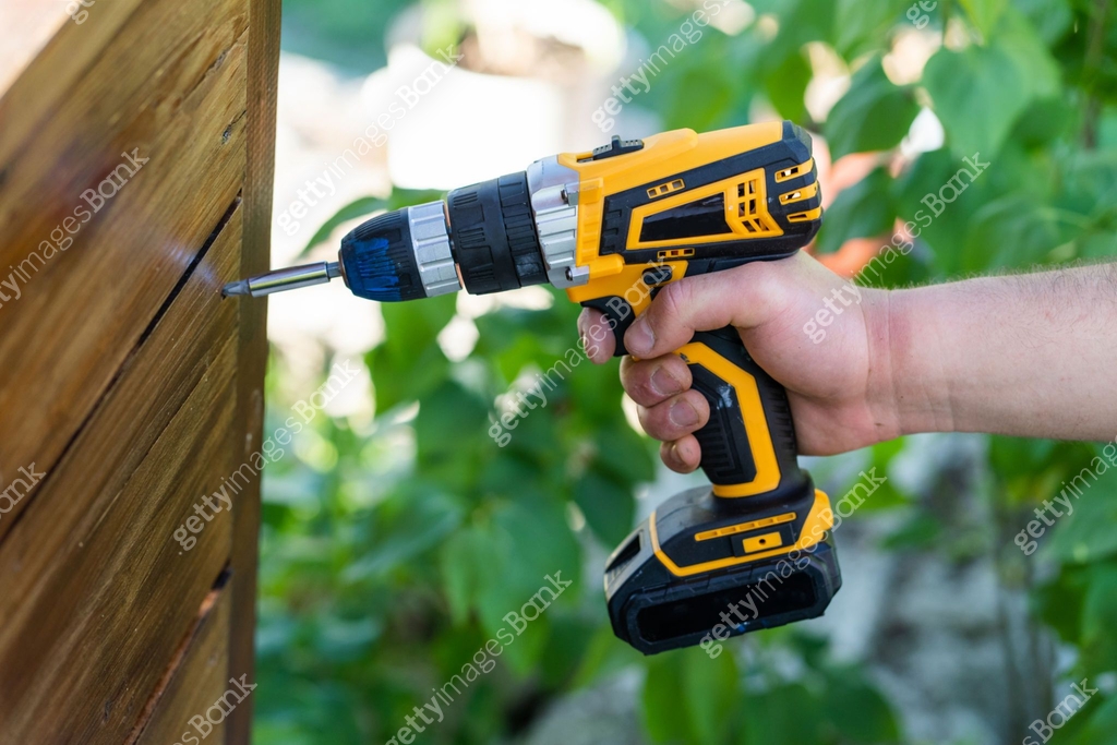 Close up on unknown man caucasian hand holding yellow electric cordless ...