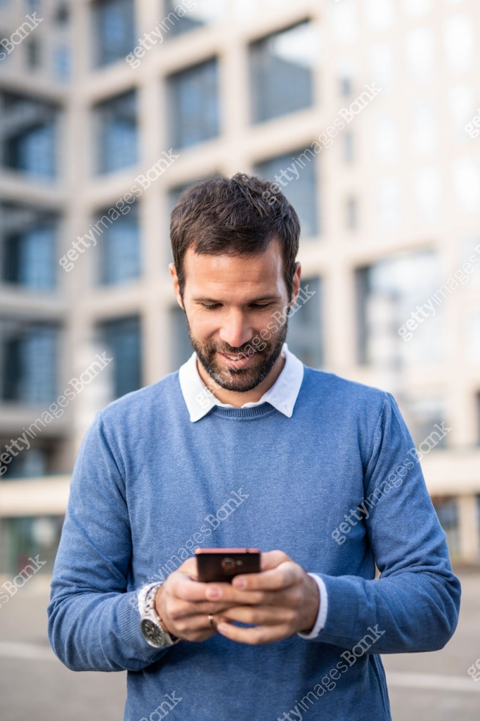 Happy mid adult man texting on phone on city street. 이미지 (1256780231 ...
