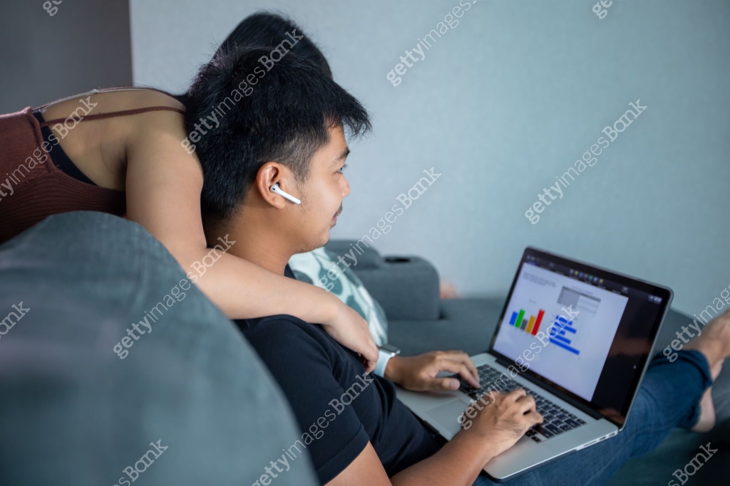Asian young smiling couple hugging and using wireless earphones and ...