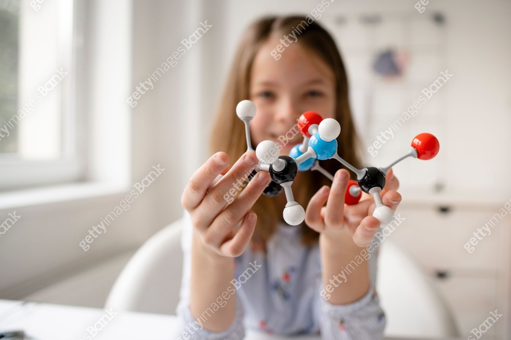 pretty blonde schoolgirl is learning chemistry with the help of a ...