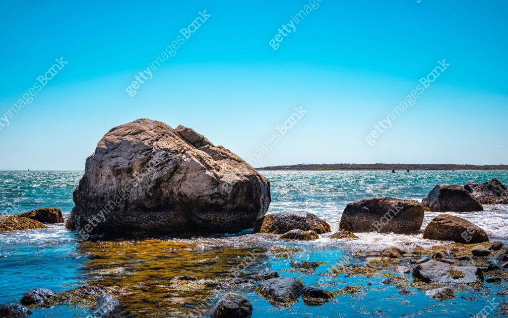 Glacial rocks on the beach on Cape Cod at the low ride. Turquoise color ...
