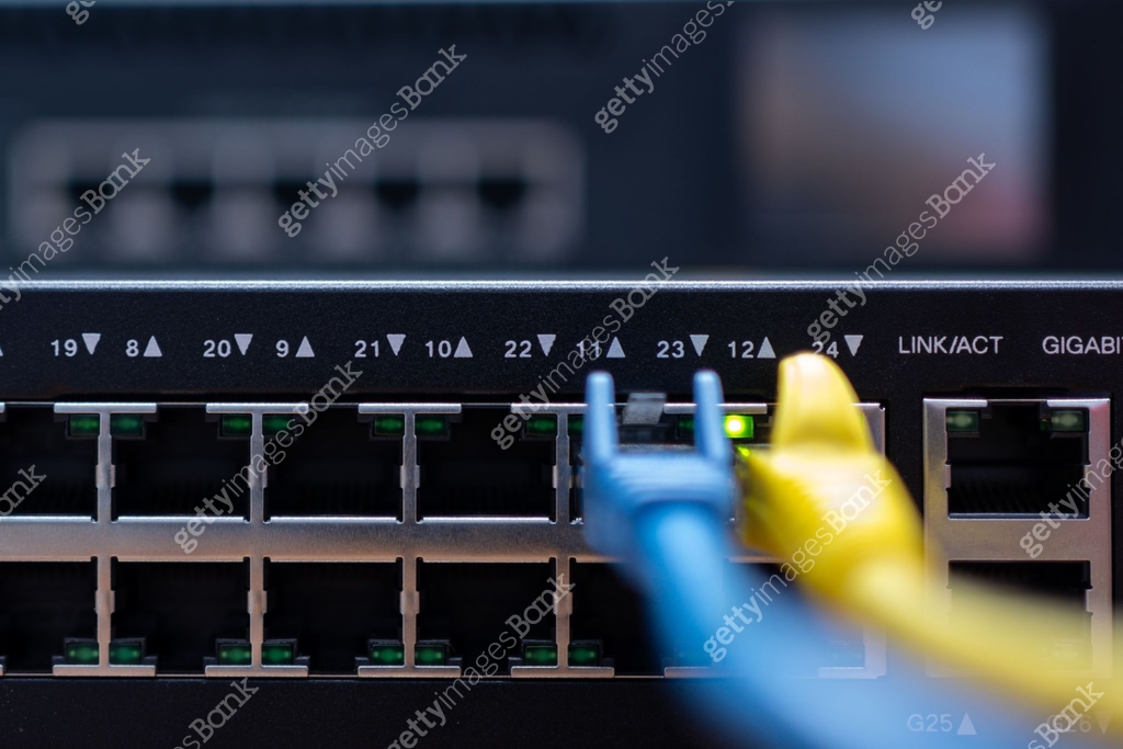 Blue and yellow network cable plugged in switch hub or router. 이미지 ...