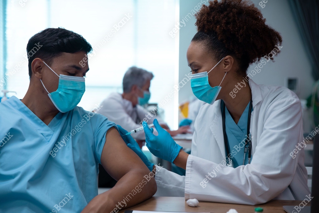 Mixtet Injection Mixed race couple of doctors wearing face masks making injection 이미지 ...