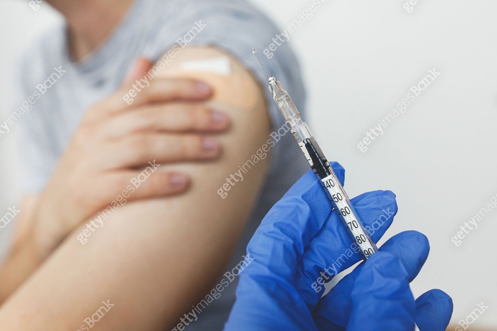 Hand in medical glove with Covid-19 vaccine on background of man with ...