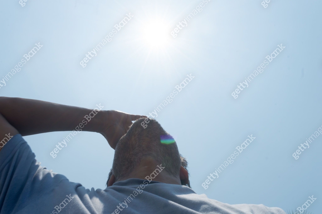 Scorching Hot summer sunlight rays pouring on human head. Hand covering ...