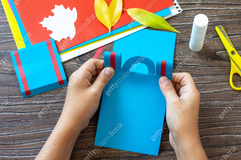 Backpack Card Paper Project Instruction step 5. Greeting card paper backpack on a wooden table ...