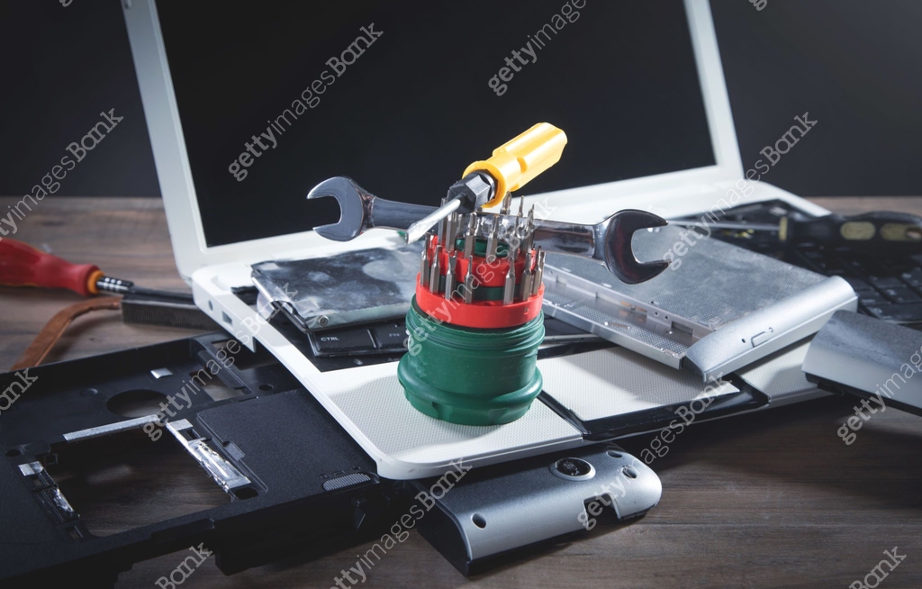 Broken laptop with a wrench and screwdriver on the table. Computer ...