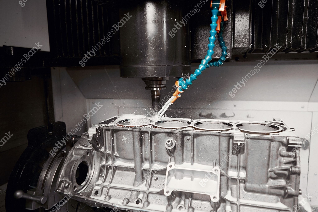Milling Block CNC milling machine grinds holes in car engine with coolant. Process of ...