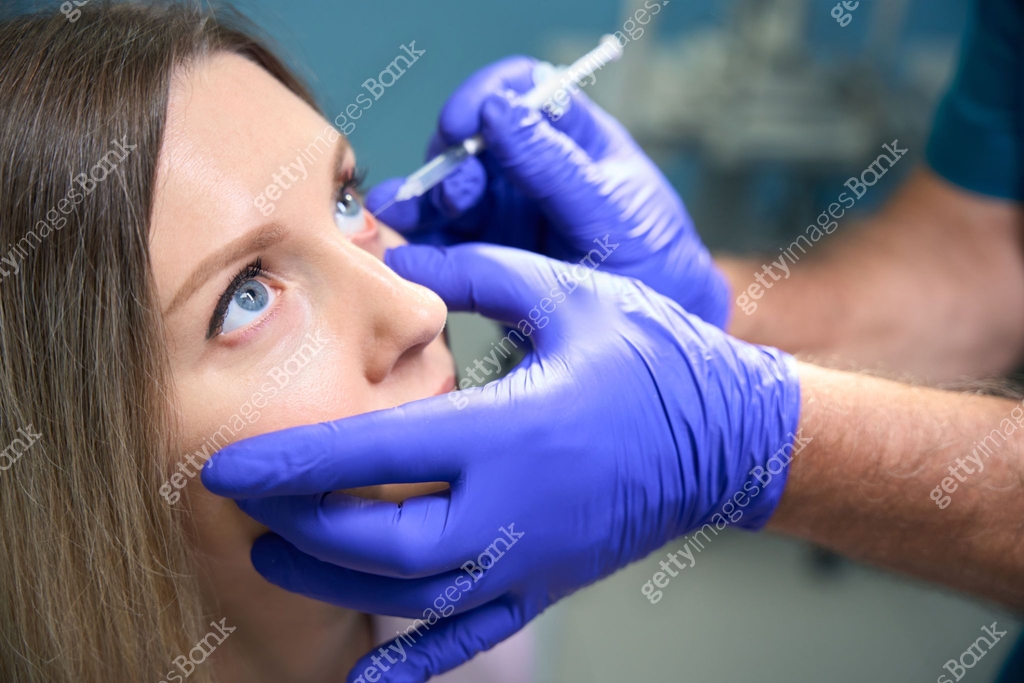 Male ophthalmologist giving injection for woman in ophthalmology clinic ...