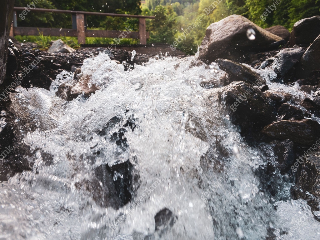 Close-up of a fast-moving mountain river: rushing waters reflecting ...
