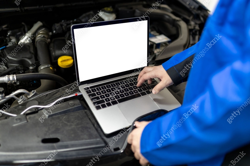 Technician using a blank screen laptop to diagnose issues under the ...