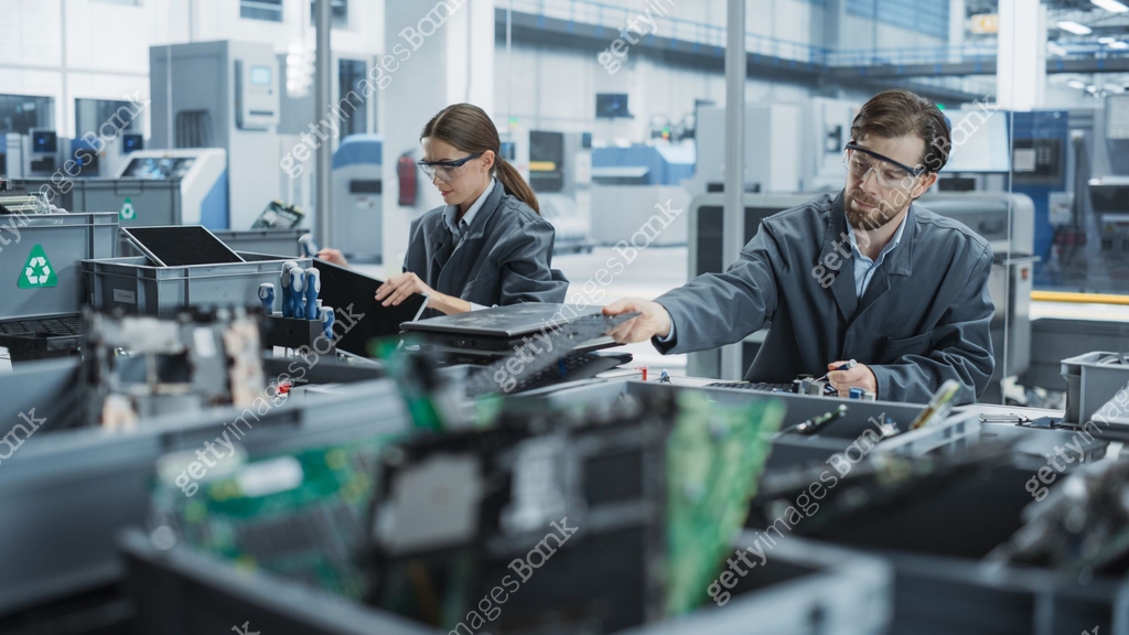 Caucasian Male And Female Employees Taking Apart Old Laptops To Recycle ...