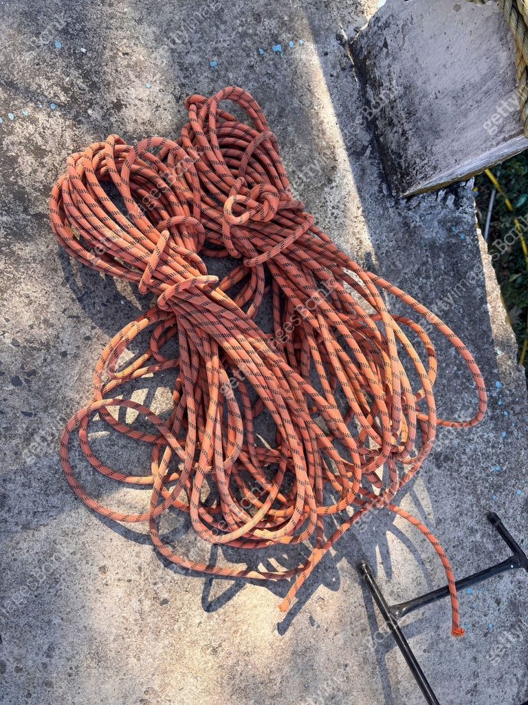 Two ropes are tied together and are laying on a cement surface 이미지 ...