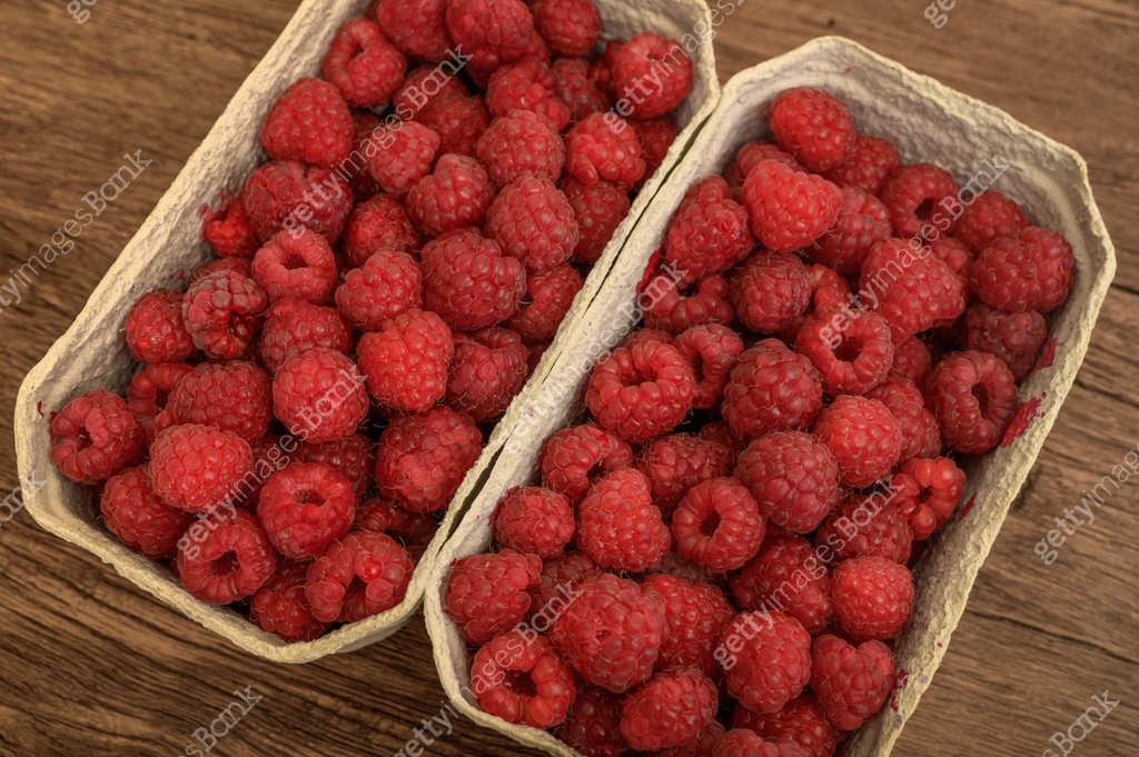 Red raspberries picked into paper containers close-up, half a kilogram ...