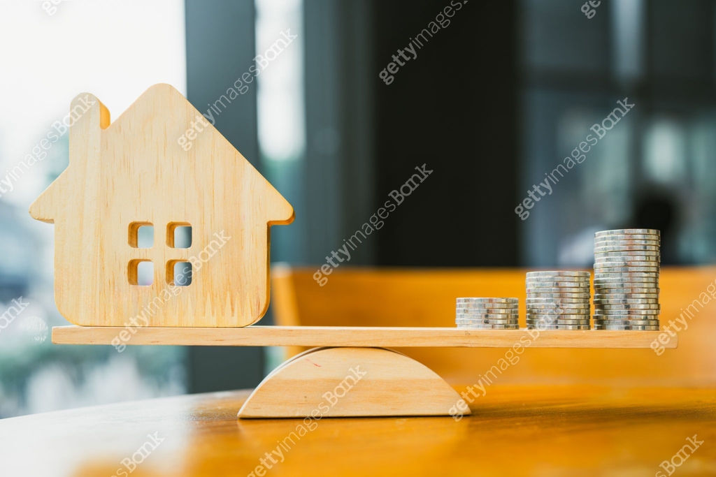 Wood house and Coins stack with balance scale. Money management ...