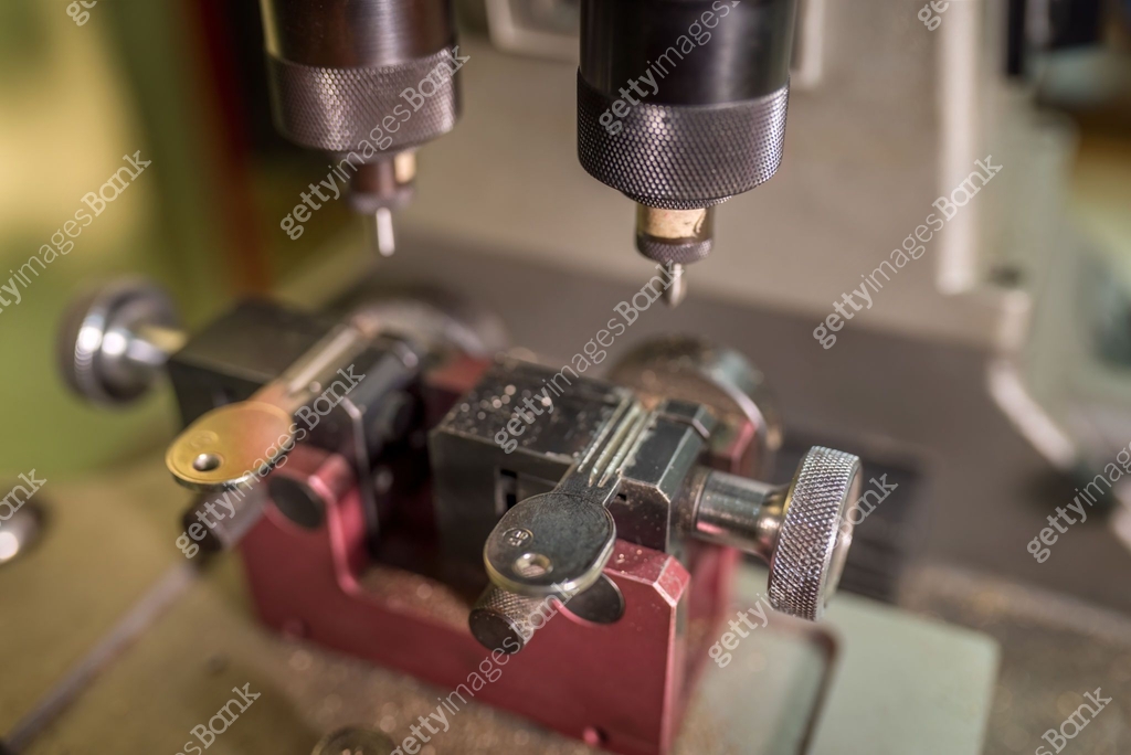 Key cutting machine duplicating key precisely, tracing original key's ...