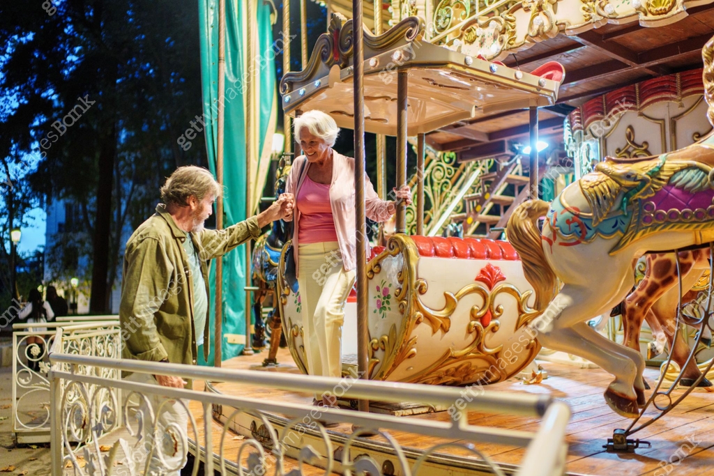 Senior couple enjoying a carousel ride at an amusement park 이미지 ...